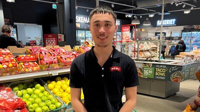 John poserer i butikken han er ansatt i.