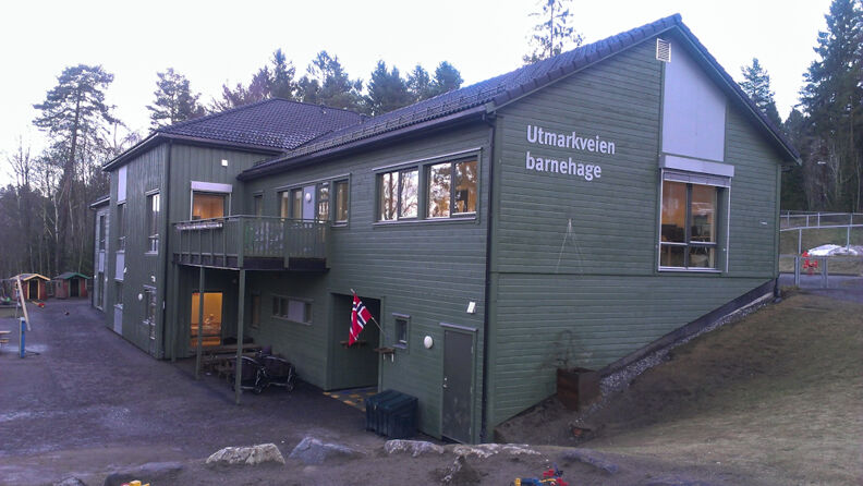 Grønmalt barnehage med skog i bakgrunnen