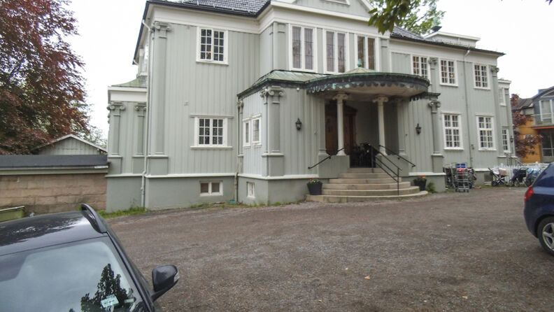 Framsiden av barnehagen,  pistasjfarget villa med parkeringsplass framfor 