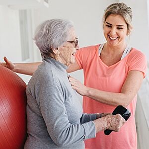 Eldre kvinne gjør øvelser sammen med personlig trener