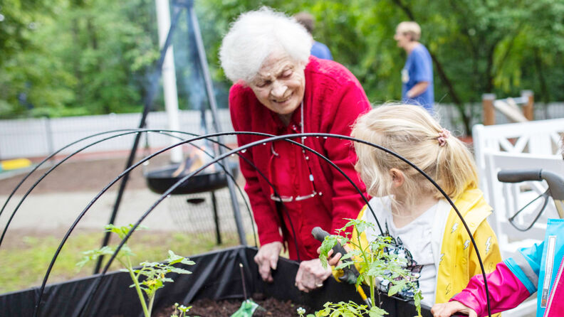 Bilde av beboer og barn ved plantekasse
