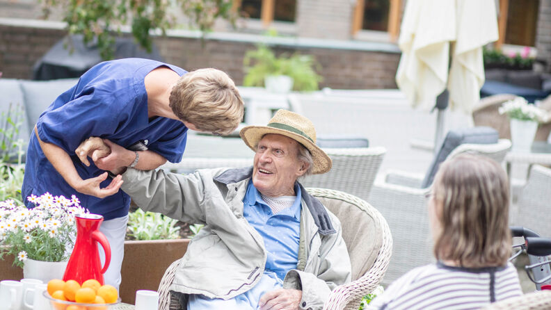 Bilde av ansatt som holder hånden til beboer