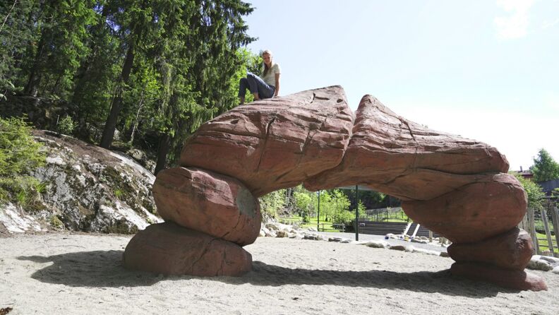 Steinbue på lekeplass med jente på toppen