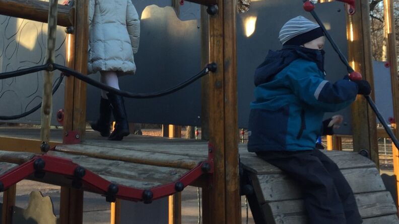 Gutt og jente leker i klatreborg
