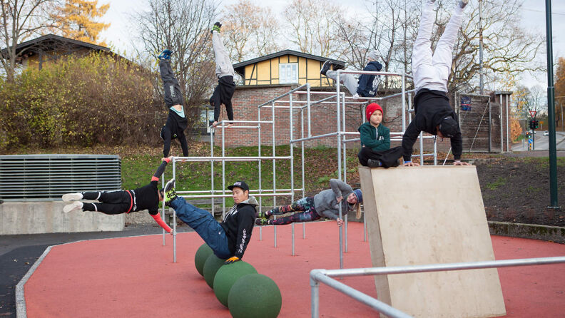 Mennesker trener kroppsvektøvelser i parkourstativet