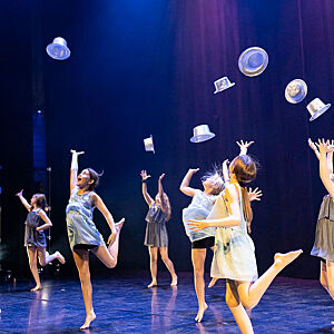Bilde av dansere som kaster hattene sinei været under en danseforestilling på Riksscenen