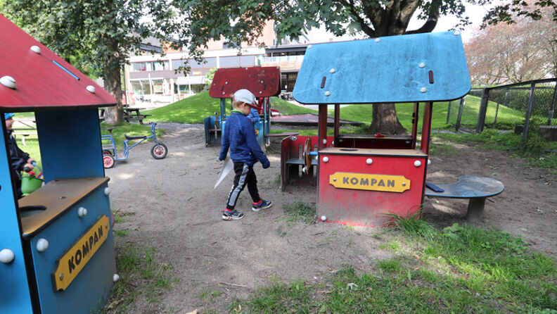 Barn som går mellom to fargerike lekehus