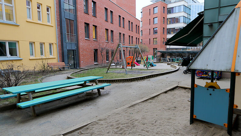 Utelekeplassen med turkis benk og lekehus