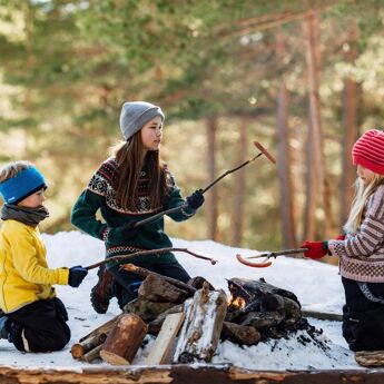 Bilde: Thomas Ekström Tre barn som griller pølser i skogen på vinteren