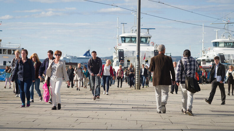 Stemningsbilde, folk på vei forbi Nesoddbåtene ved Aker Brygge.