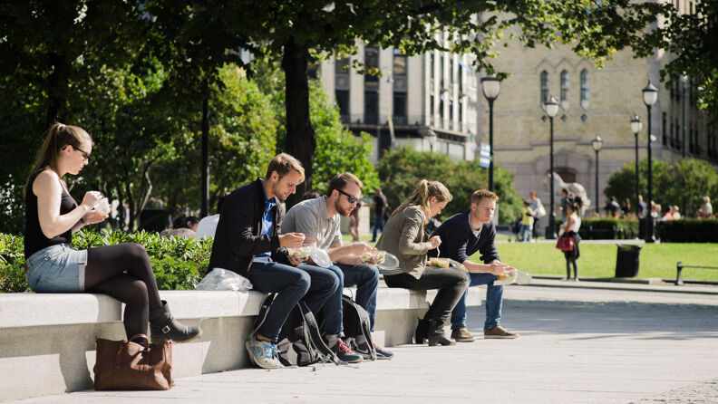 Stemningsbilde, folk spiser lunsj i sola utenfor Stortinget.
