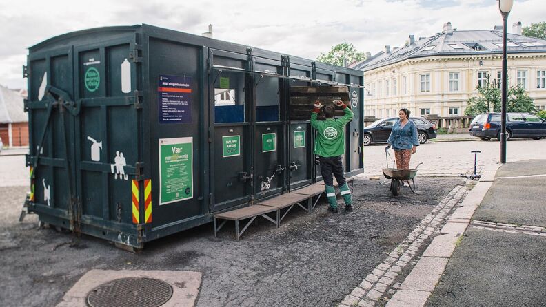 En ansatt hjelper en person med å kaste avfall i grønn container