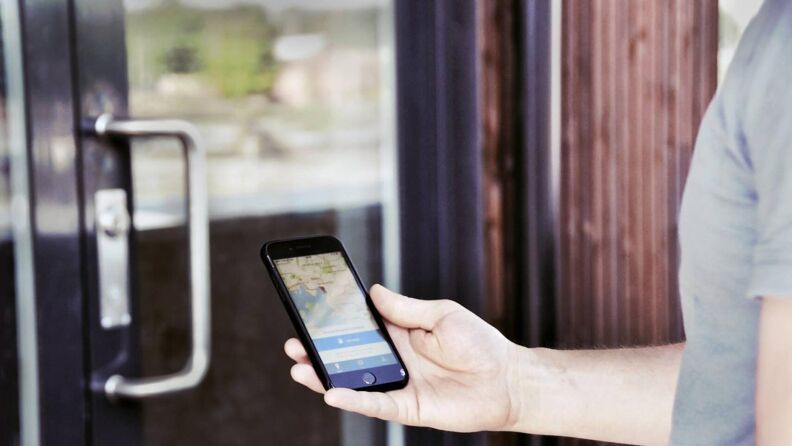 Hånd som holder en mobiltelefon