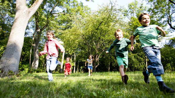 Barn som løper i gresset.