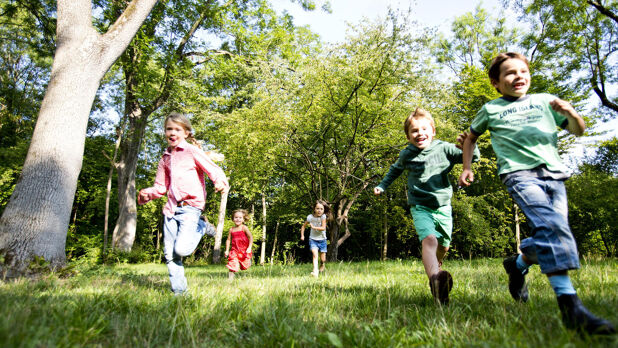 Barn som løper i gresset.