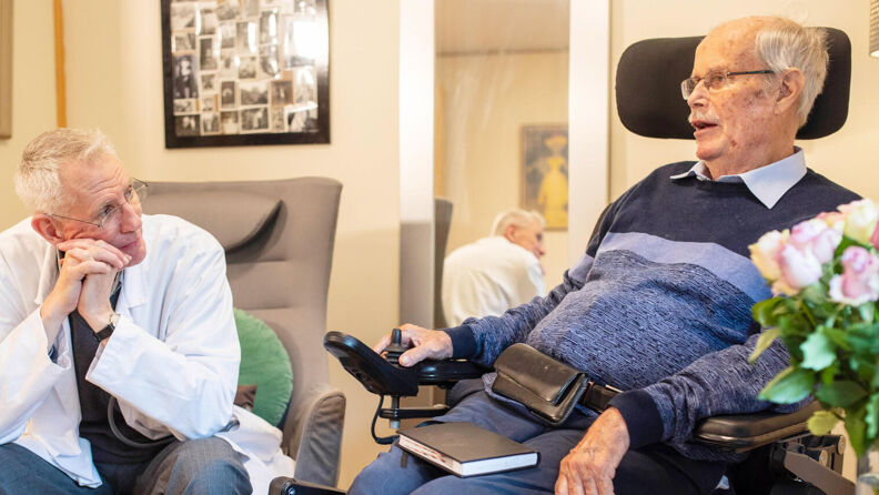 Bilde av en lege og en beboer som snakker sammen
