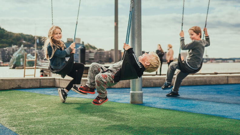 Fridtjof Nansens plass med utsikt over lekeplass, benker og rådhuset.