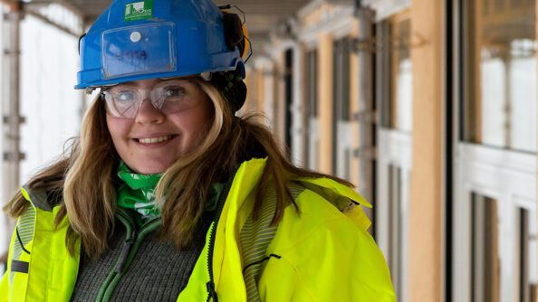 Tømrerlærling Emma Arnheim i verneutstyr og på byggeplassen