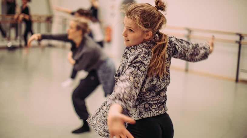 I et dansestudio på Schous kulturstasjon slår Ingvild Mæhle Skjøtskift ut med armene mens hun danser. Andre danseelever i bakgrunnen.