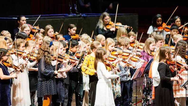 Barn spiller fiolin på scenen under en konsert på Oslo konserthus.
