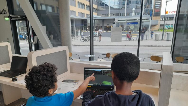 Minecraft workshop – Bilde av to barn som sitter og peker på PC skjerm