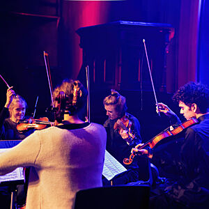 Kammerorkester spiller på scenen under en konsert