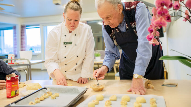 Kokk og beboer baker sammen. 