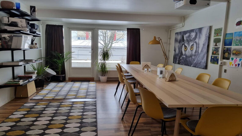 Stue med spisebord, stoler og utgang til uteområde.