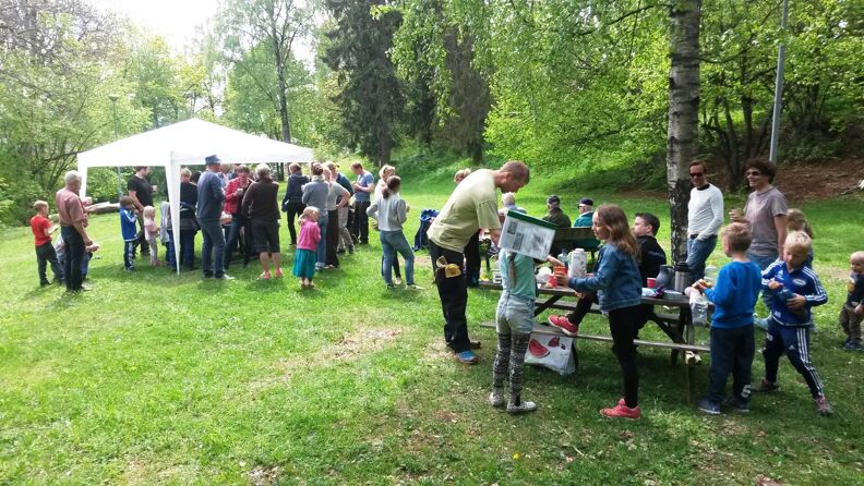 Barn og voksne deltar på dugnad for å holde Smestadparken ved like. Her tar de seg en velfortjent pause med kaffe til de voksne og saft til de små.