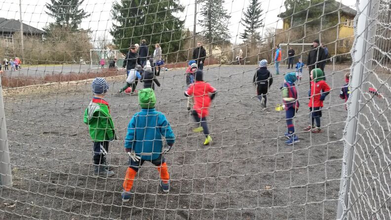 Barn spiller fotball på en av grusbanene i Smestadparken.