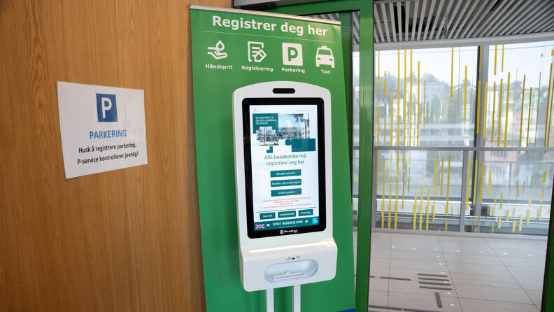 En skjerm i et inngangsparti. Skjermen viser forskjellige tjenester som er tilgjengelig for gjester og pårørende som besøker helsehuset.