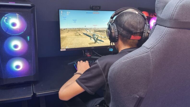 Gutt med headset som spiller PC-spill 