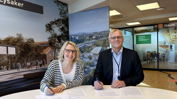 Irene Måsøval, etatsdirektør i Fornebubanen og Arild Moe, administrerende direktør i NRC Group Norge, signerer kontrakten.