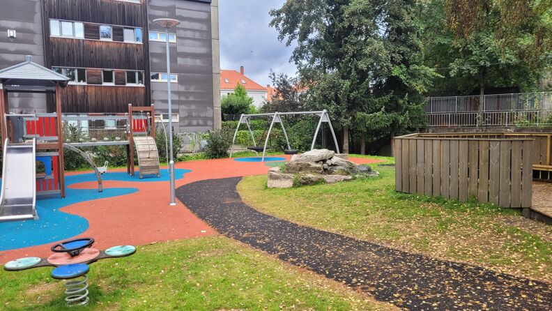 Barnehagens uteområde med sittegrupper, klatrestativer og husker 