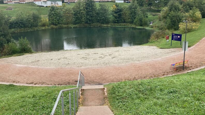 Bjerkedalen park sett fra toppen av trappen ned mot gangveien, stranden og dammen.