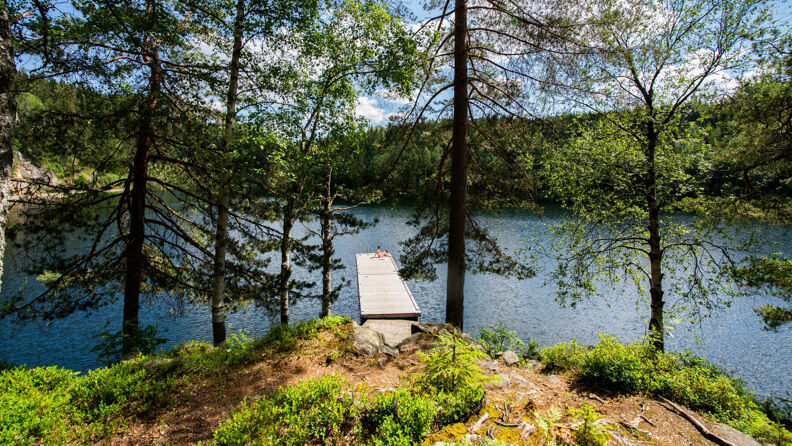 En person sitter på en badebrygge i Store Tryvann.