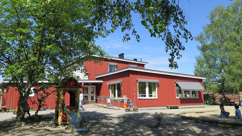 Framsiden av barnehagen, med lekeapparater