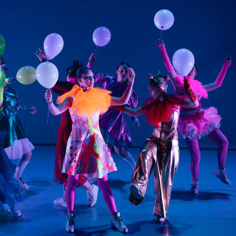 Danse-elever på scenen i fargerike kostymer