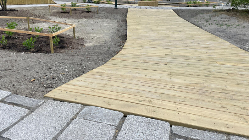 Sykkelbane av planker og stein mellom beplantning i Manglerud sykkelpark.