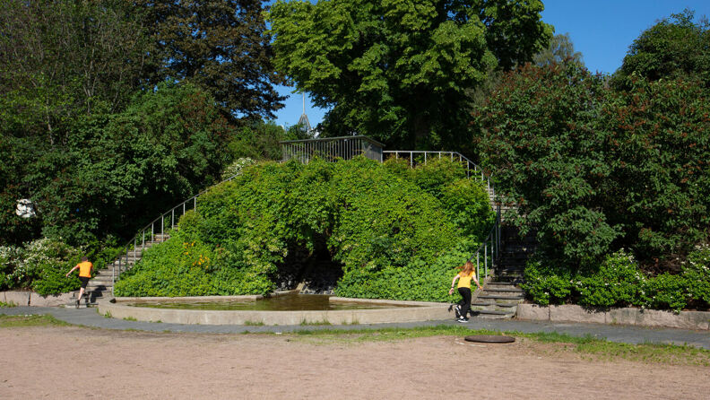 To personer løper opp hver sin trapp ved grottefontena i Kampen park.