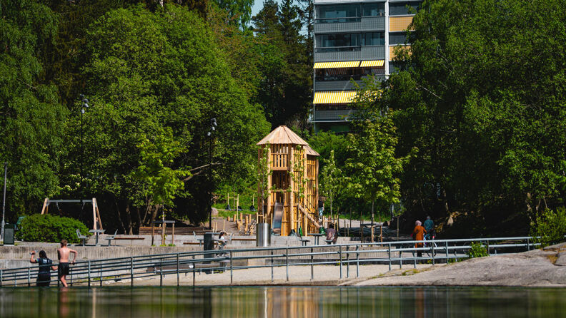 Svarttjern lekeplass med badevannet i forgrunnen.