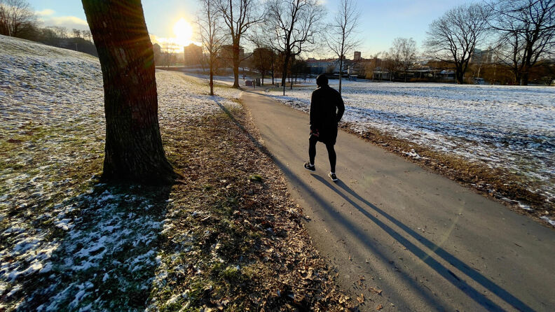 En mann går tur på en av de asfalterte veiene i Tøyenparken.
