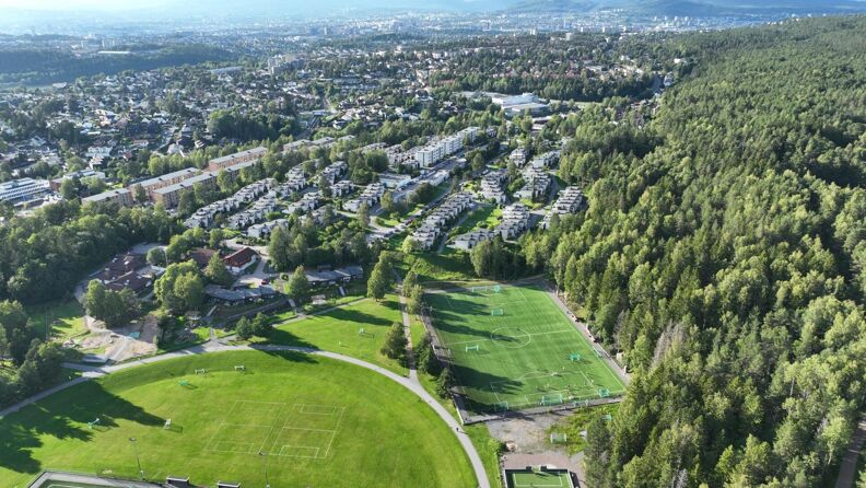 Bildet viser en fotballbane og grønne områder i stor høyde ved Østmarka i bydel østensjø.