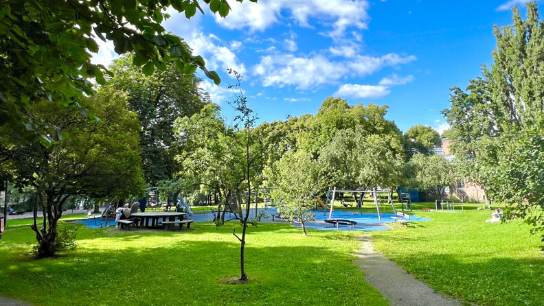 Benker, bord og lekeplass i Klosterenga park.
