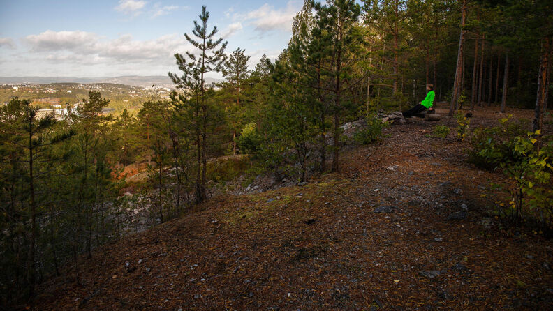 En mann sitter og ser på utsikten fra Korpåsen i Østmarka.