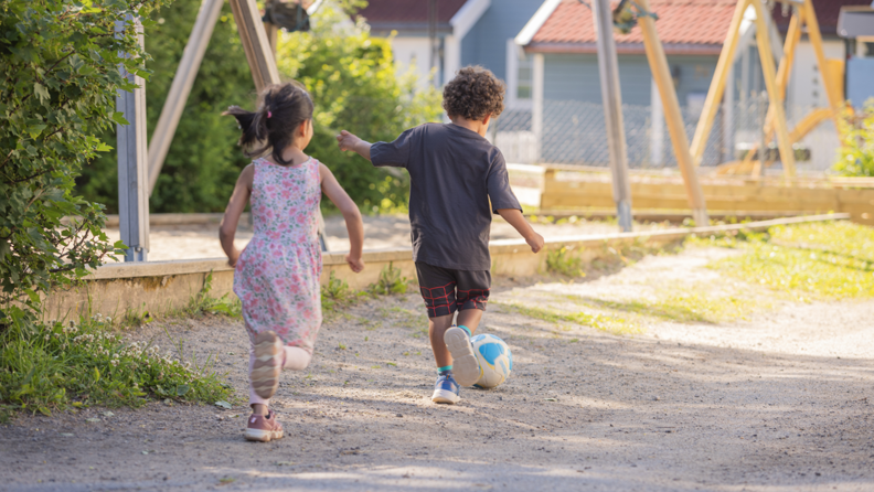 To barn sparker ball i en barnehage.
