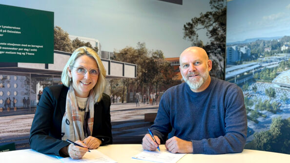 Irene Måsøval, direktør i Fornebubanen og Neal Nordahl, direktør for Veidekke Anlegg, signerer kontrakten