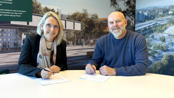Irene Måsøval, direktør i Fornebubanen og Neal Nordahl, direktør for Veidekke Anlegg, signerer kontrakten