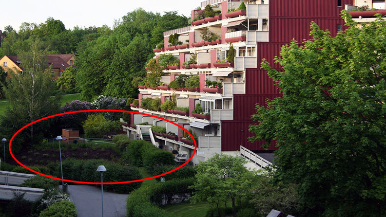 Landskapsbilde av rødmalt terraseblokk med hvite balkonger og med trær og busker rundt, rød ring der barnehagen ligger