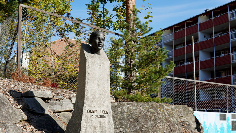 Byste med tekst "Glem ikke" plassert på et boligområde. 